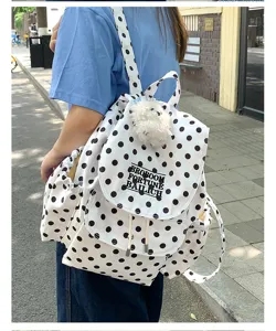Casual white polka dot backpack with plush pendant, stylish student daily shoulder bag.