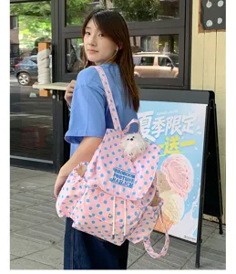 Pink blue polka dot canvas backpack casual school bag with cute plush dog pendant for daily use.