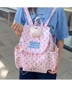 Pink polka dot backpack with plush dog pendant and front pocket, stylish casual design details.
