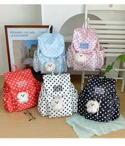 Detailed view of stylish multi-color polka dot backpacks with cute plush puppy pendants.
