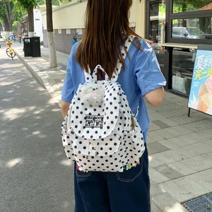 Casual canvas polka dot backpack for women, stylish daily school bag with side pockets.