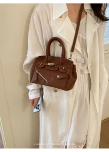 Stylish brown PU leather top-handle crossbody bag with chic front pockets and retro design.