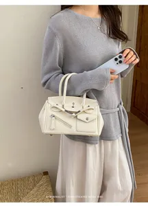 Close-up detail of white PU leather handbag with front zipper pocket and stylish metal hardware.