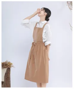 Detail view of cotton linen apron, featuring front pocket and adjustable straps, minimalist style.