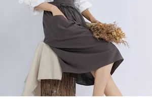 Detail shot of dark gray linen cotton apron with large pocket and tie waist for daily wear.