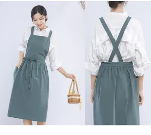 Japanese cotton linen apron detail, cross back straps, front pockets, elegant green kitchen wear.