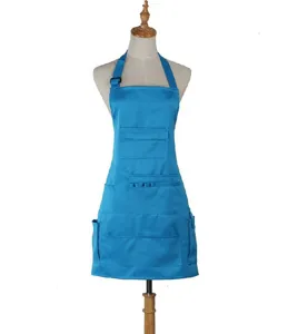 Blue work apron detail shot showing multiple utility pockets and adjustable neck strap feature.