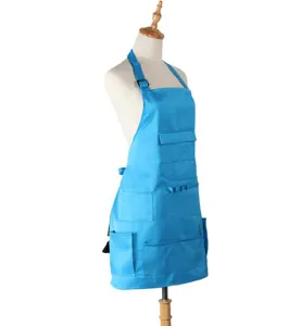 Blue work apron detail showing multiple pockets, neck strap and adjustable buckle features.