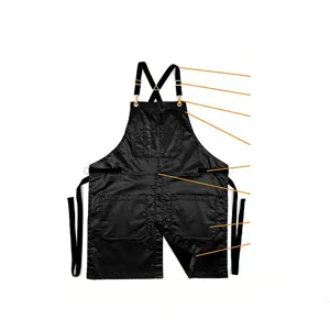 Black work apron detail showcasing cross-back straps, metal buckles, and multiple tool pockets.