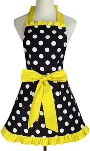 Detail view of vintage black and white polka dot apron with bright yellow bow and ruffles.