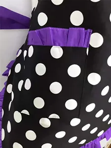 Vintage black and white polka dot apron featuring purple ruffles detail close up view.