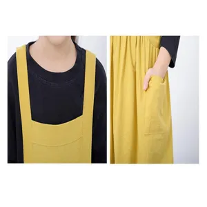 Vista dettagliata grembiule in cotone e lino per bambini, grembiulino giallo con tasca.