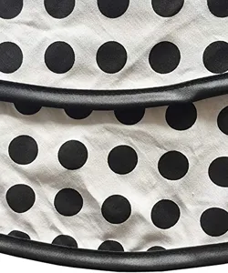 Close-up detail of vintage polka dot apron fabric with black trim, high quality cotton.