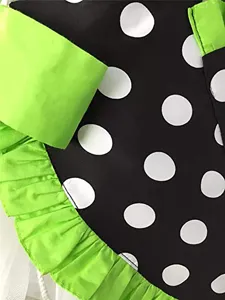 Detailed view of vintage black white polka dot apron with vibrant green ruffle trim.
