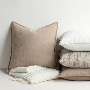 Detailed shot of textured chenille chevron throw pillow and cozy knit blanket styling.