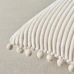 Detailed view of soft beige corduroy cushion cover featuring cute pom-pom edge design for home decor.