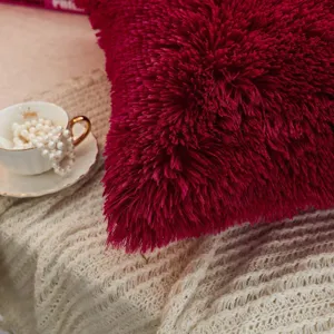 Nahaufnahme des dunkelrosa Shaggy-Zierkissens mit weicher Plüschtextur für gemütliche Wohnkultur.