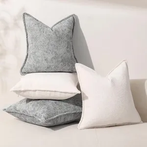 Détail de coussin décoratif en chenille texturée, tissu doux et tons neutres élégants.