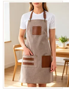 Gros plan détaillé du tablier en toile professionnelle avec poches et bretelles en cuir PU durable.