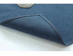 Detailed view of heavy-duty blue canvas apron with durable orange stitching and utility pocket.