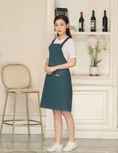 Green cotton blend work apron with cross back straps and handy front pocket for daily use.