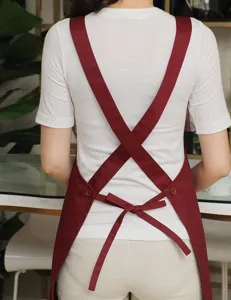 Cross-back apron detail showing adjustable straps and wine red fabric for coffee shop use.