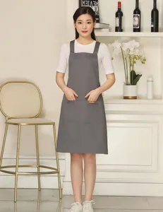 Grey polyester cotton work apron with cross straps and double pockets for kitchen or cafe.
