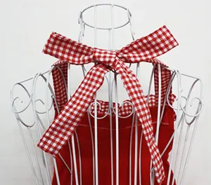 Red and white checkered bow apron detail showing adjustable straps and cute design.