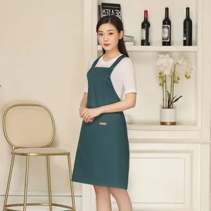 Dark green polyester cotton advertising apron with cross back straps and pockets, ideal for cafes.