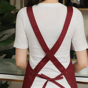 Polyester-cotton cross back apron with adjustable straps for cafe and kitchen workwear.