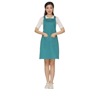 Solid color cotton blend cross back work apron with front pockets for kitchen cafe work.