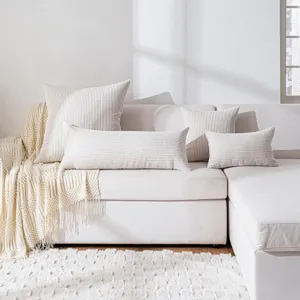 Detailed view of textured corduroy long lumbar pillow and square cushion set on a cozy white sofa.