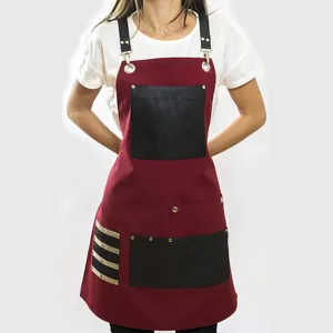Canvas work apron with leather pockets and adjustable straps for woodworking and cooking.