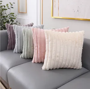 Vue détaillée d'un coussin moelleux en fausse fourrure de lapin à rayures pour le canapé.