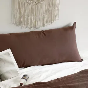 Vue détaillée du long oreiller corporel marron pour tête de lit, tissu doux, ambiance chaleureuse.