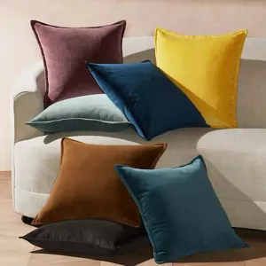 Détail de coussin décoratif en velours luxueux aux couleurs riches et texture douce.