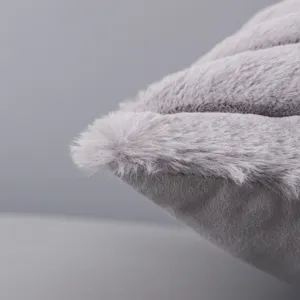 Gros plan detail de texture de coussin en fausse fourrure peluche gris doux design.