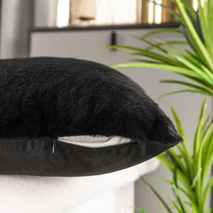 Schwarzes Plüsch Kissen Detail Nahaufnahme, weicher Fell Kissenbezug mit verdecktem Reißverschluss.