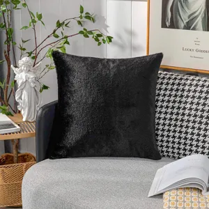 Detailansicht eines weichen schwarzen Plüschkissens auf einem modernen grauen Sofa, ideal für.