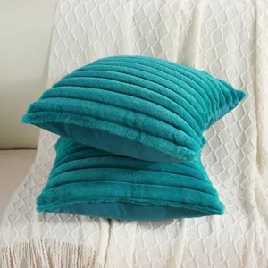 Detailed view of teal striped faux rabbit hair throw pillows, soft sofa cushion for home decor.