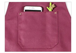 Canvas apron pocket detail, durable utility workwear with phone storage and pen holder.