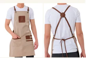 Canvas leather work apron detail, cross back straps and utility pockets for barista kitchen cooking.