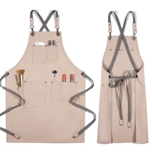 Tablier en toile épaisse avec bretelles croisées et poches multiples pour cuisine.