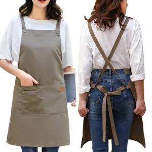 Tablier de travail en toile de coton avec bretelles croisées, idéal pour cuisine et café.
