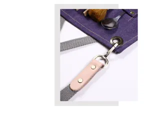Durable canvas work apron detail showing secure strap, metal buckle and reinforced leather patch.