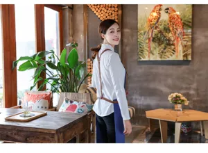 Tablier en jean de style coréen avec bretelles en cuir marron, parfait pour les cafés et bars.