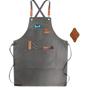 Detailed view of the thick canvas work apron pocket, showing reinforced leather and metal rivets.