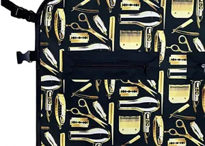 Details der schwarzen Friseurschürze mit goldenem Stylingwerkzeug-Druck und vorderer Reißverschlusstasche.