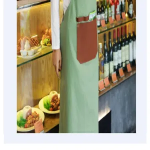 Vue detaillee du tablier vert avec une poche en cuir marron dans un charmant decor de cafe