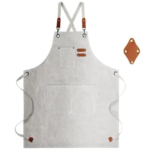 Durable canvas work apron with adjustable cross straps and utility tool pockets for daily use.